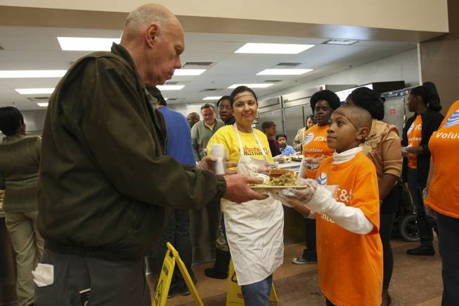 John Garrett, 8, stands first in line with volunteers handing trays of hot turkey dinners to those in need during the annual Thanksgiving community dinner at the Las Vegas Rescue Mission on Wednesday, Nov. 25, 2009.