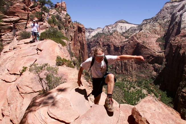 A tourist hikes up Angel's Landing at Utah's Zion National Park. The park's 2,000-foot cliffs are world-famous. 