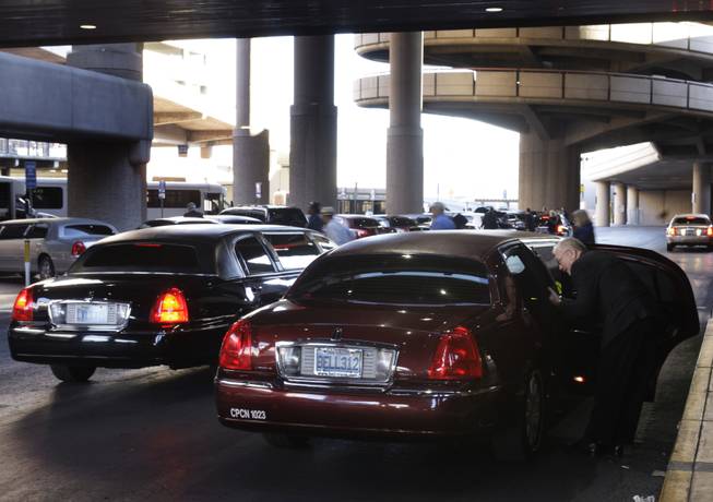 A Bell Transportation limousine driver talks to passengers after picking them up at McCarran International Airport on Thursday, Dec. 3, 2009. 