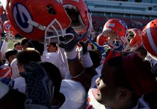 Members of the Bishop Gorman High football team hold their helmets in celebration Saturday following a 62-21 victory against Del Sol in the state championship game at Sam Boyd Stadium.