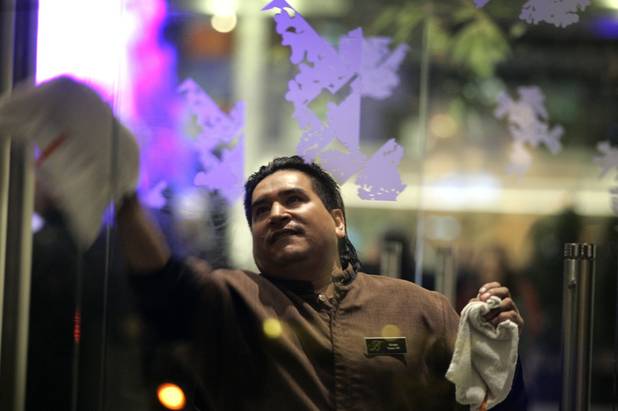 Alvaro Parga, a utility porter, cleans the windows of the ...