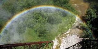 As a train engine releases steam, a rainbow is formed high above the Des Moines River near Boone, Iowa.
