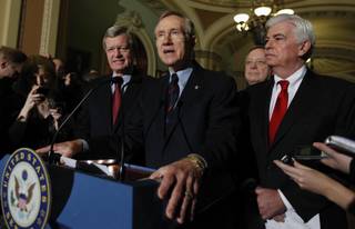 Senate Majority Leader Harry Reid of Nevada, center, answers questions outside of the Senate chambers on Capitol Hill in Washington, Thursday, Dec. 24, 2009, after the Senate passed the health care reform bill. From left are, Senate Finance Finance Committee Chairman Sen. Max Baucus, D-Mont., Reid, Senate Majority Whip Richard Durbin of Ill., and Senate Banking Committee Chairman Sen. Christopher Dodd, D-Conn.