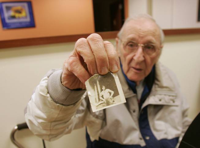 Vincent Cravero, a client at the center for adults, shows a photo of himself when he was in the Army during World War II.  