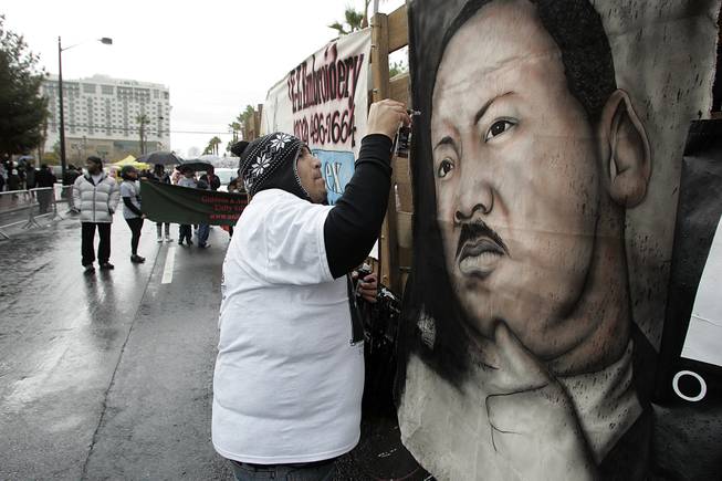A man who gave his name as "Airbrush" Robito paints a portrait of Martin Luther King while marching in the annual Martin Luther King Day parade down 4th Street Monday, January 18, 2010.