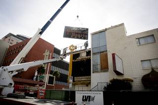 YESCO workers remove the Queen of Hearts Hotel sign after the demolition ceremony for the hotel, part of the ongoing construction to build a new City Hall and office complex in downtown Las Vegas Tuesday, February 2, 2010. The sign will be stored at the Neon Boneyard.