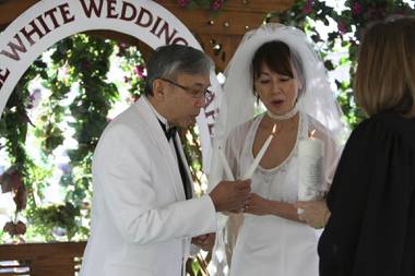 After lighting a unity candle and making a wish, Ken and Yuko Tachibana of Palo Alto, Calif., blow out each other’s candles during their wedding ceremony on Valentine’s Day 2010 at the Little White Wedding Chapel in Las Vegas.