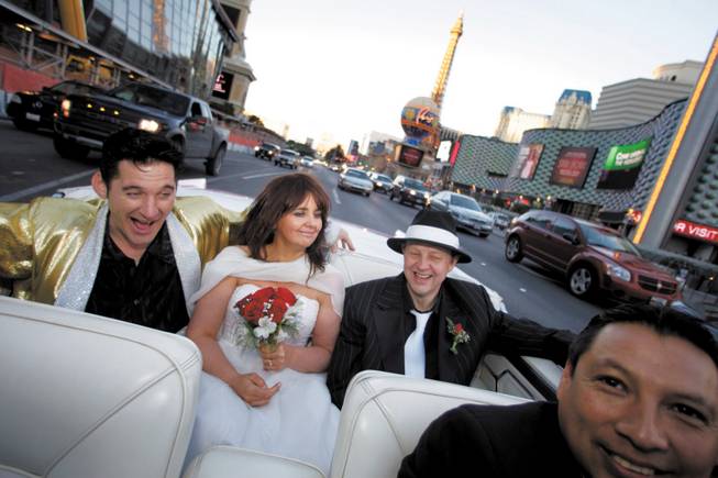 
Elvis impersonator Roddy Ragsdale entertains Lynn Hassell, 46, and Neil Cawkwell, 45, of Ascot, England, during their ride along the Las Vegas Strip last month after being married at the Little White Wedding Chapel. Driver Oscar Villegas is at right. 