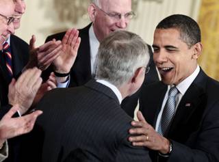 U.S. President Barack Obama, right, is congratulated by Senate Majority Leader Harry Reid, center, after signing the Omnibus Public Lands Management Act of 2009, in the East Room of the White House in Washington, D.C., on March 30, 2009.