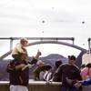 Tourists walk on the sidewalk along the Hoover Dam, with construction of the dam bypass bridge seen in the background Friday, Feb. 26, 2010.
