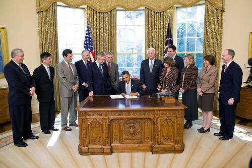 President Barack Obama signs the tourism bill. 