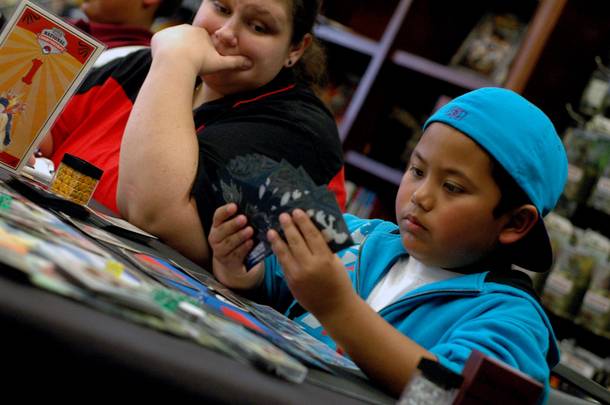 A judge watches 8-year-old Patrick Martinez during the junior division championship round of the Pokemon Trading Card Game Nevada State Championship.