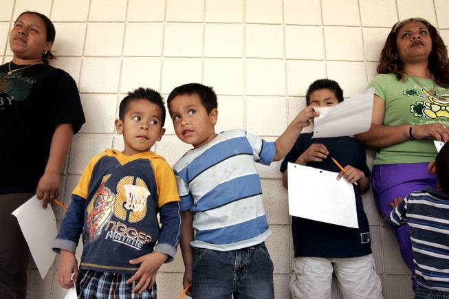 Martin Zamora, left, 5, and Cesar Padilla, 7, talks while listening to instructions about a math exercise with their families during math night at Herron Elementary School in North Las Vegas Wednesday, March 24, 2010.