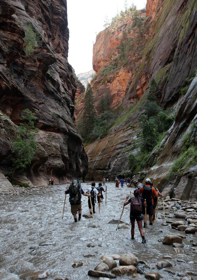 In this Sept. 5, 2009 file photo, hikers wade through the Virgin River at the entrance to The Narrows in Zion National Park, Utah. 