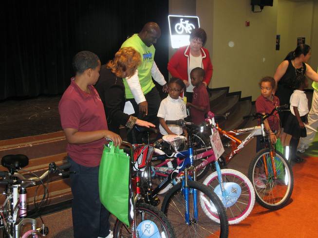 Look Out Kids About President Robin Munier, Councilman Ricki Barlow and Councilwoman Lois Tarkanian show kids the bicycles the youngsters won at a Nevada Moves Day event at Agassi Prep.