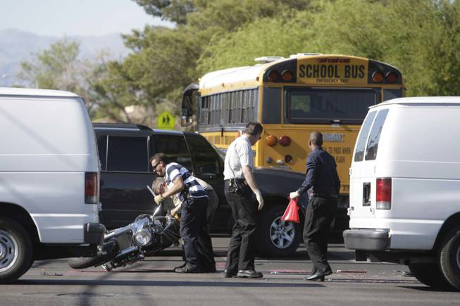 Investigators upright a motorcycle as they investigate a fatal accident between the motorcyclist and a school bus on Sahara Avenue by Knudson Middle School Monday, May 3, 2010. Police said the bus ran over the motorcyclist after the collision. No other injuries were reported. No children were on the bus, police said. Traffic on Sahara was closed in both directions during the investigation.