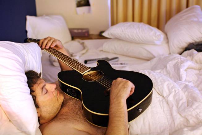 Tom Urbanski practices guitar while bedridden at his temporary Residence ...