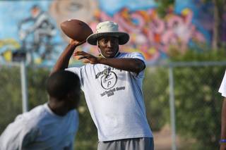 Oklahoma defensive back Quinton Carter runs reception drills while coaching his youth football team during a football camp Sunday night at Ed Fountain Park in 2010.