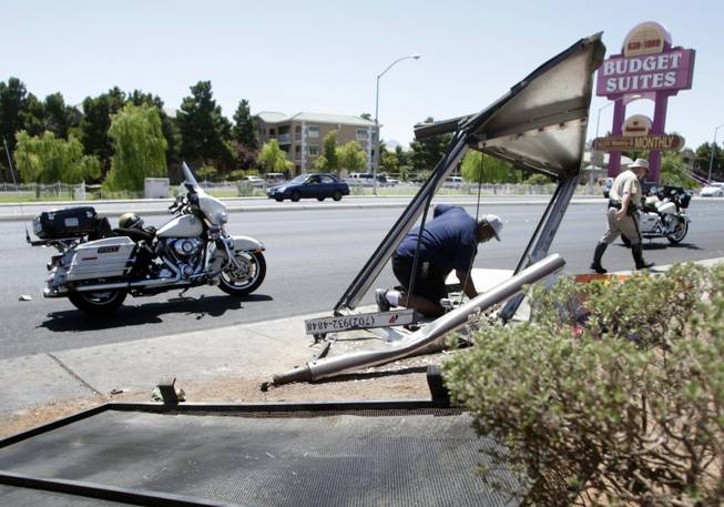 Reginald Lovett, an employee of Outdoor Promotions, disconnects electricity from a bus shelter after a pickup truck ran into the shelter on Rancho Drive just north of Lake Mead Boulevard Monday, June 21, 2010. The driver of the truck, a person waiting at the bus shelter and the driver of another vehicle were transported to the hospital, police said.