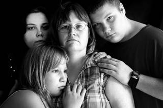 Michelle Butts, center, and her children, from left, Stephanie Hilaman, 21; Lisa Butts, 12; and Dennis Butts, 15, are shown this summer at their Mountain Grove, Mo., home.