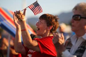 Michelle Parker applauds during the playing of patriotic songs during Henderson's Fourth of July celebration Sunday night at Basic High School.