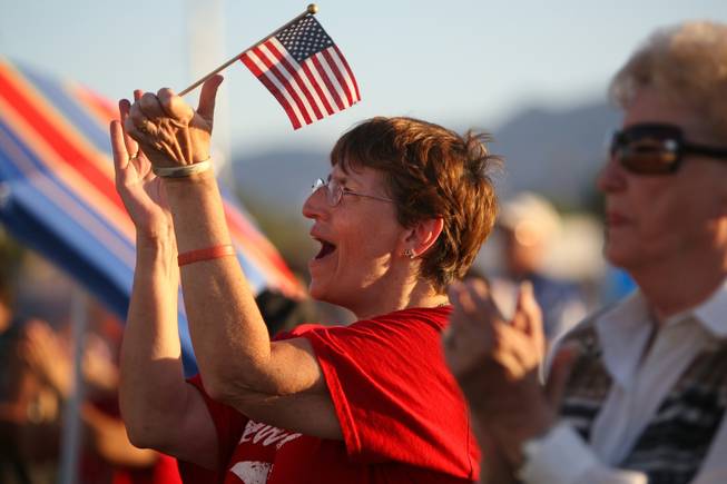Michelle Parker applauds during the playing of patriotic songs during Henderson's Fourth of July celebration Sunday night at Basic High School.