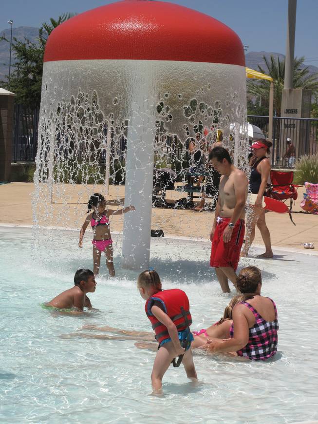 Children and adults cool off at the Desert Breeze Aquatic Center's pool.