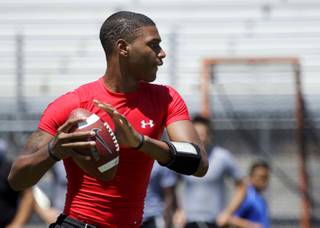 Las Vegas High quarterback Hassan Henderson looks for a receiver during a passing league tournament in August 2010.