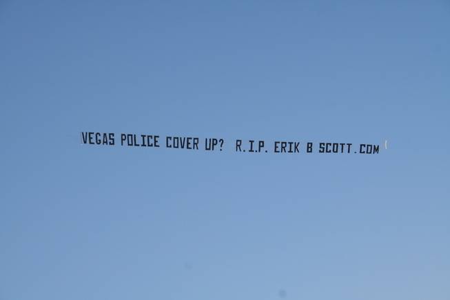During a surfing competition in Huntington Beach, Calif., a plane tows a banner questioning the shooting death of Erik Scott by Metro Police in Las Vegas. Family and friends of Scott raised money for the banner and for billboards to keep attention focused on the case.