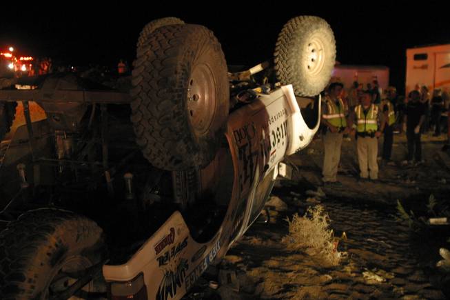 Emergency workers look at an off-highway vehicle that lost control and barreled into a crowd of spectators on Saturday, Aug. 14, 2010 at an off-road race called the California 200 being held at Johnson Valley Off-Highway Vehicle Area, killing eight people and leaving 12 wounded, authorities said. 