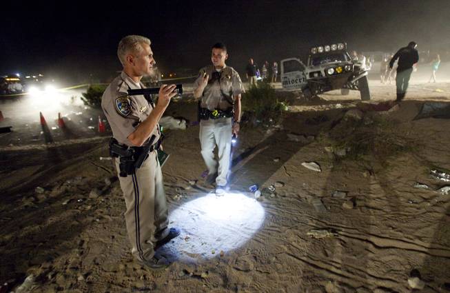 California Highway Patrol officers examine the accident scene Sunday where an off-road race truck went out of control and plowed into a crowd of spectators during a race in Lucerne Valley, Calif., Saturday Aug. 15, 2010. At least eight people were killed and 12 injured during the incident about 100 miles east of Los Angeles.