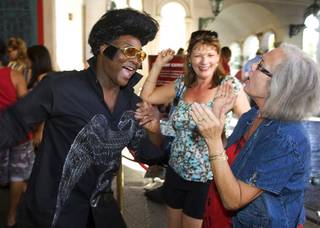 Elvis Presley impersonator Larry Edwards, left, dances with Sallie Mitchell, center, and Nancy Ledvina, both of Fort Worth, Texas, outside the Madame Tussauds Las Vegas wax museum Monday, August 16, 2010. To mark the 33rd anniversary of the King's death, the museum played Elvis records, hired Elvis impersonators and gave free admission to anyone dressed as Elvis.