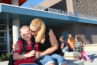 Second-grader Dakota Congioloso receives a goodbye kiss from his mom, Sabrina, as he heads off to his first day of class Monday, August 30, at Ruby Duncan Elementary School.