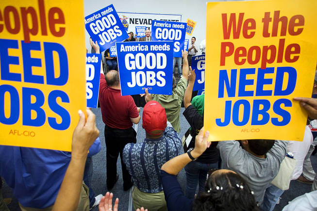 Union members hold up signs during a rally at the Painters and Allied Trades, District Council 15 and Local Union 159, union hall in Henderson Thursday, Sept. 9, 2010. The rally of union members and unemployed workers was held to attack Republican Senate candidate Sharron Angle for her position against "creating" jobs.