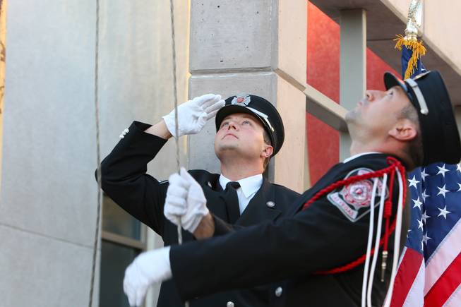 Firefighter Nick Celeste salutes as firefighter/paramedic Joseph Digaetano lowers the ...