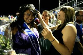 Lacey Romo and her boyfriend, Anthony Rush, laugh as Romo has her tiara adjusted by Cheyenne Wells after Romo was named queen during halftime of Basic's homecoming game against Silverado on Friday. Basic won 24-21.