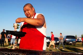 Ronnie Luenza grills Saturday during the tailgating at Star Nursery Fields, north of Sam Boyd Stadium just before the Rebels take on New Mexico.