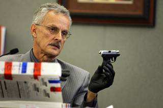 Metro Police Detective Peter Calos holds a .38 caliber handgun owned by Erik Scott during a coroner's inquest for Erik Scott at the Regional Justice Center Monday, September 27, 2010. The gun was said to be found in Scott's pocket by medical workers in the ambulance.