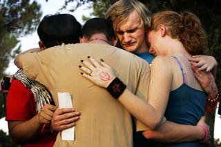 Isaiah Quiambao, 16, from left, Franklin Watkins, 18, Patrick Woodruff, 17, and Crystal Watkins, 16, all students at Chapparal High School and friends of Tanner Chamberlain, embrace during a vigil Wednesday at Sunset Park for Chamberlain on the one-year anniversary of his death. Chamberlain, 15, was shot by a Metro officer as he threatened his mother with a knife, police said.