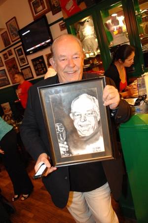 Robin Leach with his charcoal portrait at Hussong's Cantina in Mandalay Place.