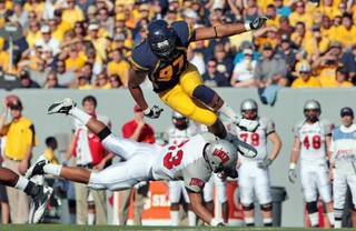 West Virginia's Julian Miller tries to avoid the block by UNLV's Sidney Hodge during an  NCAA college football game Saturday, Oct. 9, 2010 in Morgantown, W.Va. 
