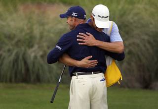 Jonathan Byrd hugs his caddie Adam Hayes after winning the Justin Timberlake Shriners Hospitals for Children Open golf tournament at TPC Summerlin Sunday, October 24, 2010. Byrd made a hole-in-one during a playoff round to beat Cameron Percy and last year's champion Martin Laird.