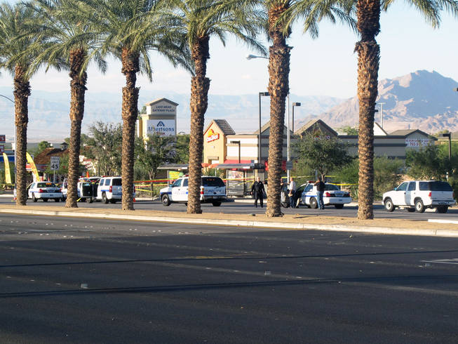Henderson police investigate a shooting on Boulder Highway near Lake Mead Parkway Saturday afternoon. Officers said a man suspected of robbing a check-cashing store apparently shot himself after police ordered him to leave his car.	