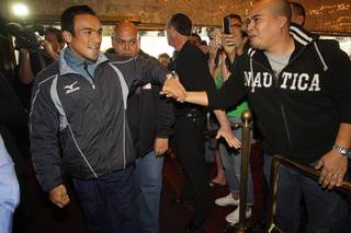 WBA/WBO lightweight champion Juan Manuel Marquez, left, of Mexico greets a fan as he arrives for a pre-fight press conference in the lobby of the MGM Grand Tuesday, November 23, 2010. Marquez will defend his titles against Michael Katsidis of Australia at the MGM Grand Garden Arena on Saturday.