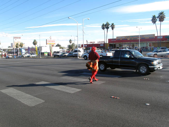 Officer Michael Lemley crosses Charleston Boulevard dressed in a turkey costume as part of an enforcement campaign Tuesday.