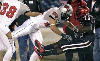 San Diego State running back Ronnie Hillman gets drilled out of bounds by UNLV's Alec DeGiacomo after gaining 15 yards in the first quarter of a NCAA college football game, Saturday, Nov. 27, 2010, in San Diego.