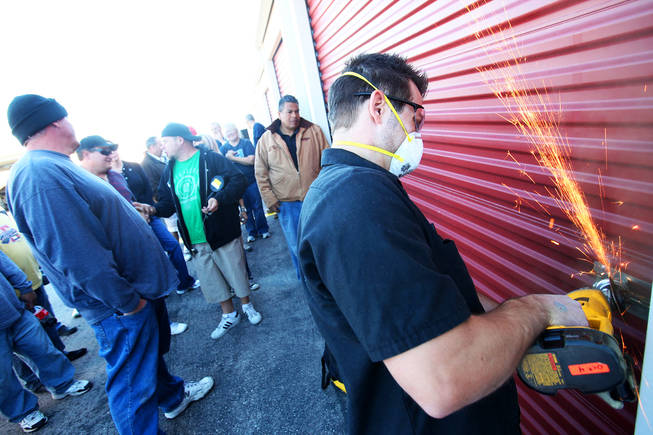Owner of Lock Chopper, Dustin Mclaughlin, cuts a lock to a stoage locker that is up for auction during the Las Vegas Storage One auctions Tuesday, December 7, 2010.
