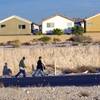 Pedestrians pass by a housing development in the southwest valley on Dec. 9, 2010.