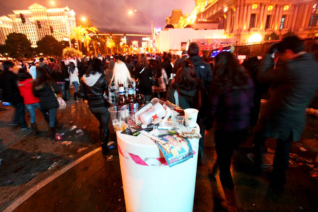Trash gathers as partygoers walk past on the Las Vegas Strip early New Years Day 2011.