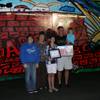 Krista Kachnik of John Dooley Elementary School poses with family in front of an RTC bus covered with her winning artwork in an anti-graffiti contest.